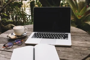 Młoda kobieta pracuje na lekkim laptopie siedząc w kawiarni, idealnym dla cyfrowych nomadów.