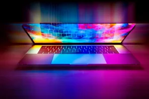 Młoda osoba korzysta z nowoczesnego laptopa w jasnym, komfortowym pomieszczeniu, idealnym do skupionej nauki, efektywnej pracy oraz relaksującej rozrywki.